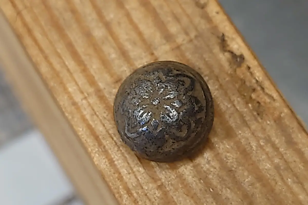 En rund knapp med mönster som liknar en blomma.