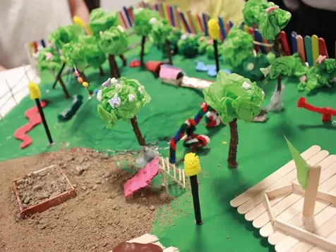 En modell av en lekplats gjord av piprensare, glasspinnar, tändstickor och prasselpapper. 